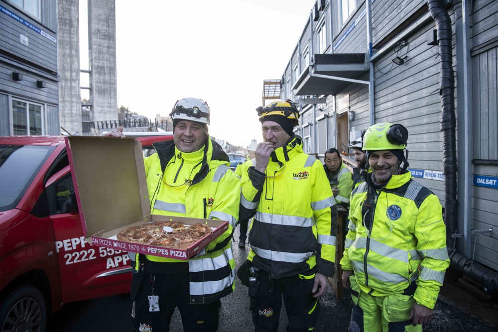 spiser pizza på byggeplassen