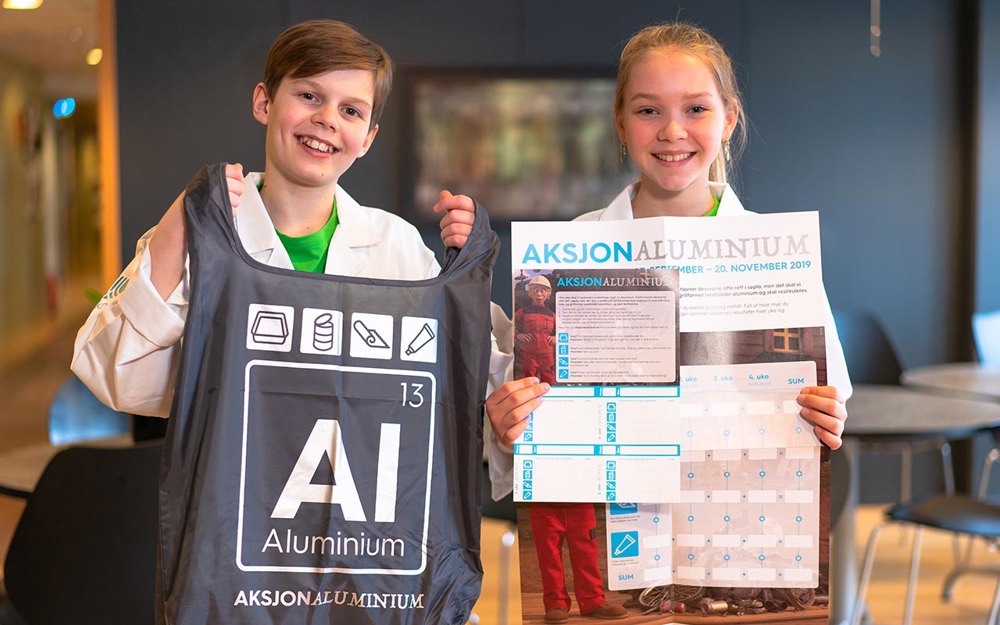 To barn som holder opp reklame for aksjon aluminium. 